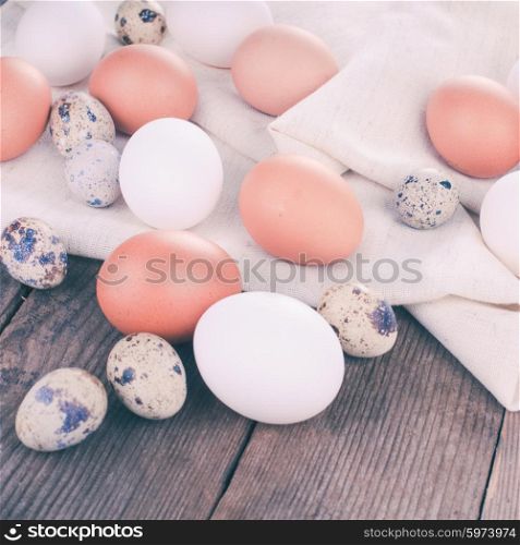 Eggs on textile tablecloth over rustic wooden table. Eggs on textile