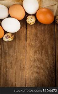 Eggs on textile tablecloth over rustic wooden table with copyspace