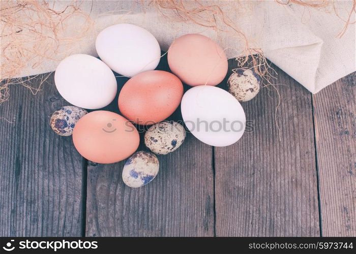 Eggs on textile tablecloth over rustic wooden table with copyspace. Eggs on textile