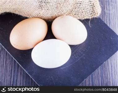 Eggs over black stone chopping board, horizontal image