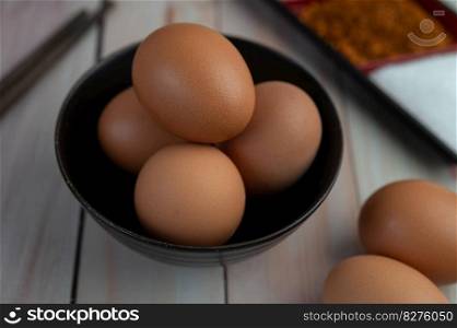 Eggs placed in a cup on a wooden floor. Selective focus.