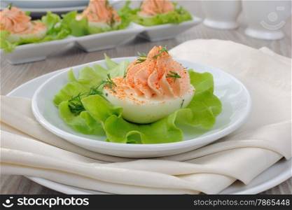 Eggs stuffed with pate salmon with red pepper in lettuce leaves
