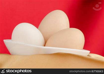 Eggs,Three eggs in the bowl on a red background.