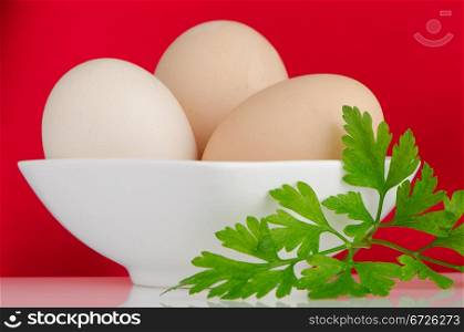 Eggs,Three eggs in the bowl on a red background.