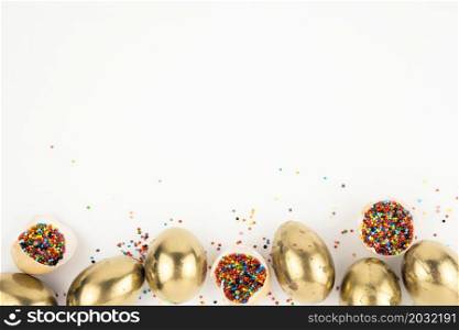 eggshells with sprinkles near golden eggs