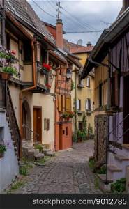 Eguisheim, France - 29 May, 2022: narrow cobblestone street with colorful historic half-timbered houses
