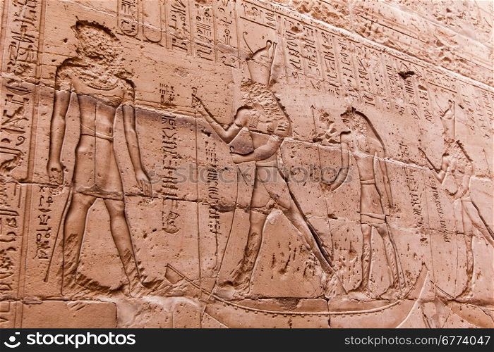 Egyptian hieroglyphics on the stone wall. Ancient stone carved Egyptian hieroglyphics