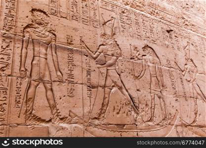 Egyptian hieroglyphics on the stone wall. Ancient stone carved Egyptian hieroglyphics