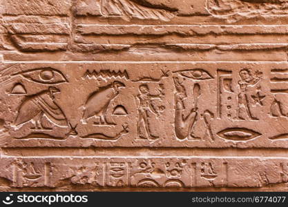 Egyptian hieroglyphics on the stone wall. Ancient stone carved Egyptian hieroglyphics