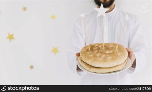 eid al fitr concept with man holding plate bread