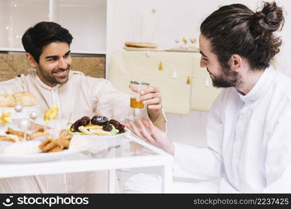 eid al fitr concept with people eating table