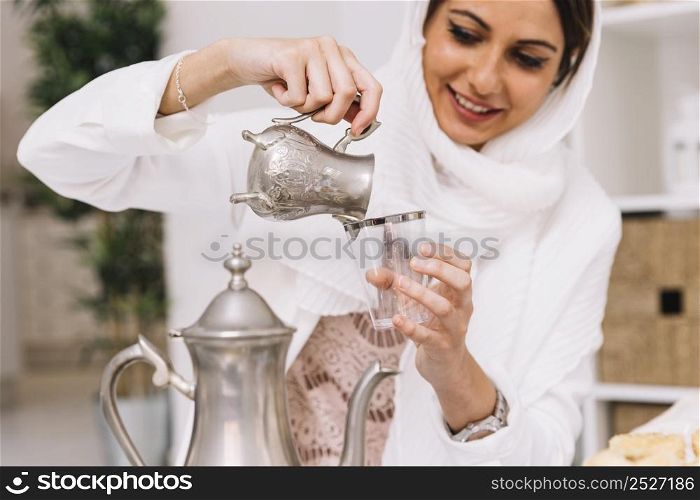 eid al fitr concept with woman pouring tea