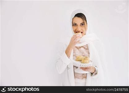 eid concept with woman holding arab pastry