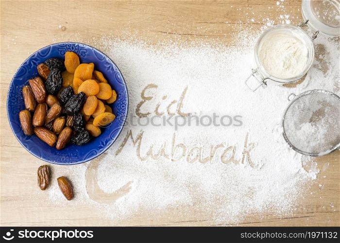 eid mubarak inscription flour near dried fruits. High resolution photo. eid mubarak inscription flour near dried fruits. High quality photo