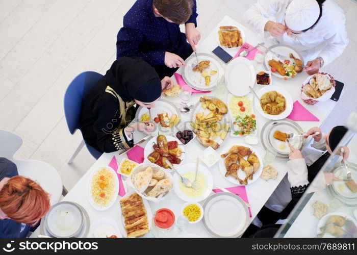 Eid Mubarak Muslim family having Iftar dinner  Eating traditional food during Ramadan feasting month at home. The Islamic Halal Eating and Drinking Islamic family top view