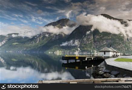 eidfjord in norway with mountains clouds and buildings of the jetty from the ferry to Voss