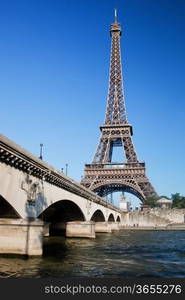 Eiffel Tower and bridge on Seine river in Paris, France at a sunny day