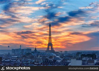 Eiffel Tower at sunset in Paris, France. Aerial view of Eiffel tower and the rooftops of Paris during a gorgeous sunset, France
