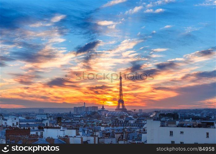 Eiffel Tower at sunset in Paris, France. Aerial view of Eiffel tower and the rooftops of Paris during a gorgeous sunset, France