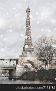 Eiffel Tower in Paris, France in gloomy winter day in snowstorm. Pastel trendy toning. Beautiful inspiring moody faded scenery