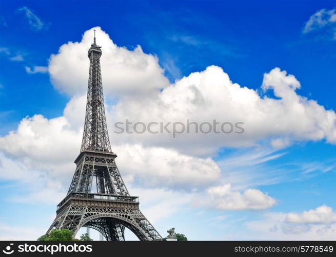 Eiffel Tower (La Tour Eiffel) against cloudy blue sky. Champ de Mars, place of interest in Paris, Europe