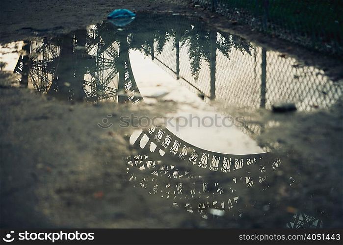 Eiffel Tower reflected in puddle
