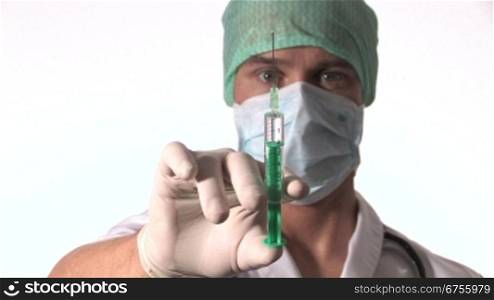 Ein Arzt hebt eine Hand und hSlt eine aufgezogene Injektion in die Kamera.