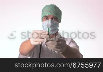 Ein Arzt hebt seine Arme und hSlt eine aufgezogene Injektion in den HSnden.