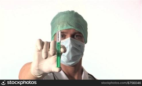 Ein Arzt hSlt eine aufgezogene Spritze in der Hand und senkt den Arm. Gleichzeitig fShrt die Kamera auf sein Gesicht zu.