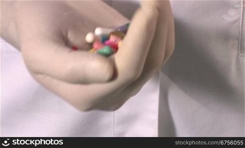 Ein Arzt oder eine Krankeschwester hSlt mehrere Pillen in der Hand