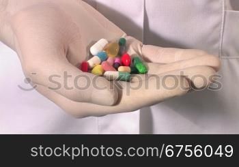 Ein Arzt oder eine Krankeschwester nimmt eine handvoll Pillen aus der Tasche des Kittels