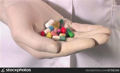 Ein Arzt oder eine Krankeschwester nimmt eine handvoll Pillen aus der Tasche des Kittels
