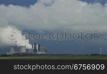 Ein gewaltiger Rauch eines Energiekraftwerks steigt in den blauen Himmel