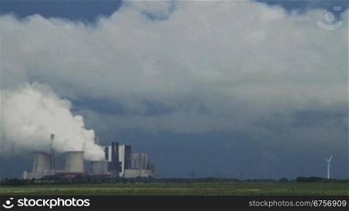 Ein gewaltiger Rauch eines Energiekraftwerks steigt in den blauen Himmel
