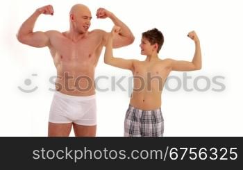 Ein Junge schaut bewundernd auf die Muskeln eines Bodybuilders. A boy looks admiring at the muscles of a bodybuilder.