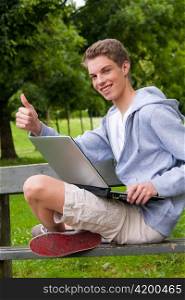 Ein junger Mann mit Laptop Computer im Freien