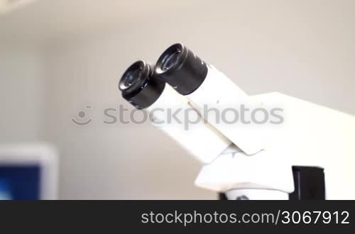 ein Mann kommt in die Szene und guckt in das Mikroskop