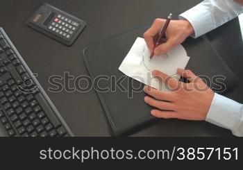 Eine CD wird mit einem Stift beschriftet