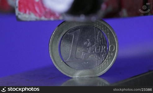 Eine Ein-Euro-Mnnze wird unter einer Presse zerdrnckt.