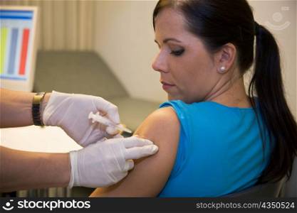 Eine junge Frau wird bei einem Arzt gegen Grippe geimpft