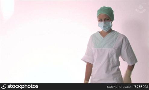 Eine Krankenschwester nimmt den Mundschutz ab, verschrSnkt die Arme und lSchelt anschlie?end