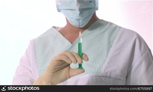 Eine Krankenschwester schnipst auf eine Spritze bis ein wenig Flnssigkeit rauskommt