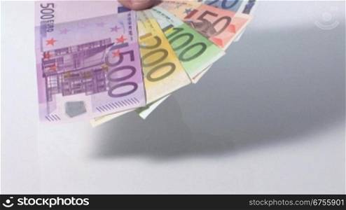 Eine MSnnerhand hSlt einen FScher aus Euro-Geldscheinen, Kamerafahrt vorwSrts