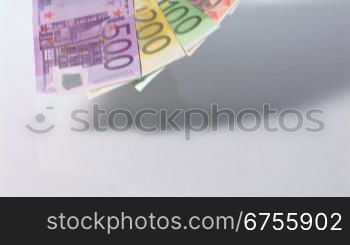 Eine MSnnerhand hSlt einen FScher aus Euro-Geldscheinen, Kamerafahrt zurnck.