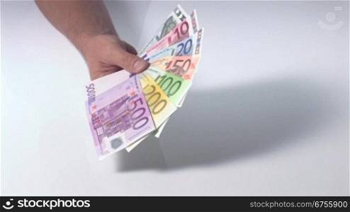 Eine MSnnerhand schwenkt einen FScher aus Euro-Geldscheinen ins Bild.