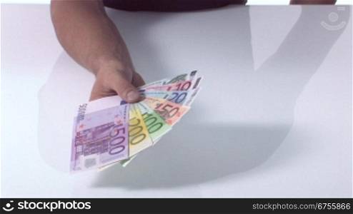 Eine Person hSlt mehrere Euro Geldscheine als FScher in der Hand