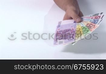 Eine Person hSlt mehrere Euro Geldscheine als FScher in der Hand