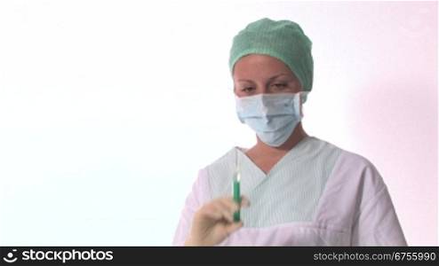 Eine -rztin oder Krankenschwester hSlt eine Spritze in der Hand und tippt diese an