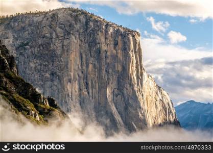 El Capitan rock close-up in Yosemite National Park Valley at cloudy autumn morning from Tunnel View. Low clouds lay in the valley. California, USA.