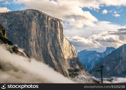 El Capitan rock close-up in Yosemite National Park Valley at cloudy autumn morning from Tunnel View. Low clouds lay in the valley. California, USA.